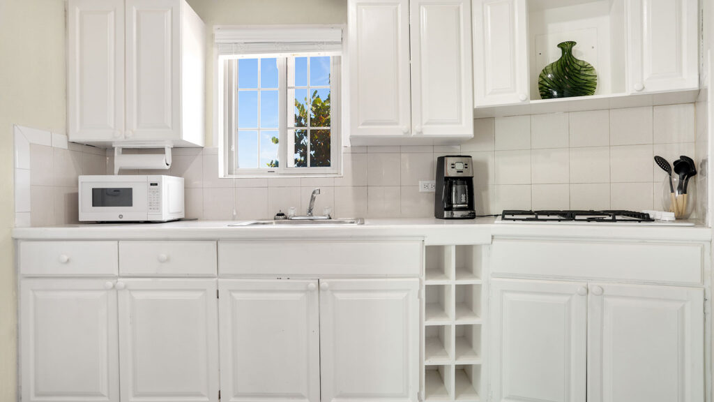 Arawak_suite-10-1_1600 Kitchenette with white cabinets, coffee maker, and window in the Starfish Suite at Arawak Beach Club in Anguilla