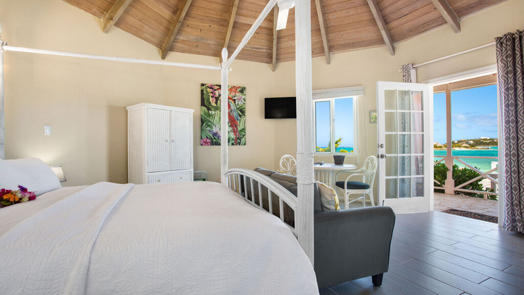Arawak_suite-10-2_1600 Four-poster king bed with sitting area and vaulted ceiling in the Starfish Suite at Arawak Beach Club in Anguilla