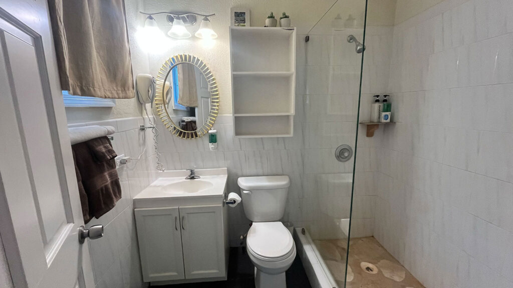 Arawak_suite-2-1_1600 Bathroom vanity with mirror and glass shower in the Pelican Suite at Arawak Beach Club in Anguilla