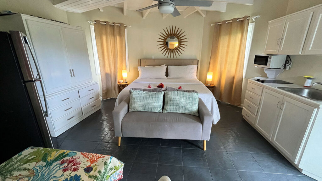 Arawak_suite-2-5_1600 Bright bedroom with king bed, neutral decor, and ceiling fan in the Pelican Suite at Arawak Beach Club in Anguilla