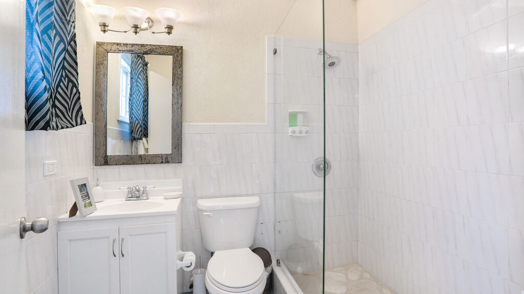 Arawak_suite-3-2_1600 Bathroom with walk-in shower, toilet, and vanity in Arawak Beach Club suite in Anguilla