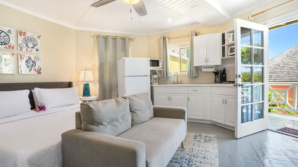Arawak_suite-4-1_1600 Open-concept layout with sofa, kitchenette, and ceiling fan in the Blue Horizon Suite at Arawak Beach Club in Anguilla