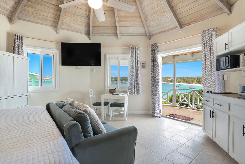 Arawak_suite-5-2_1600 Living area with ocean view, sofa, and vaulted ceiling in the Sea Breeze Suite at Arawak Beach Club in Anguilla