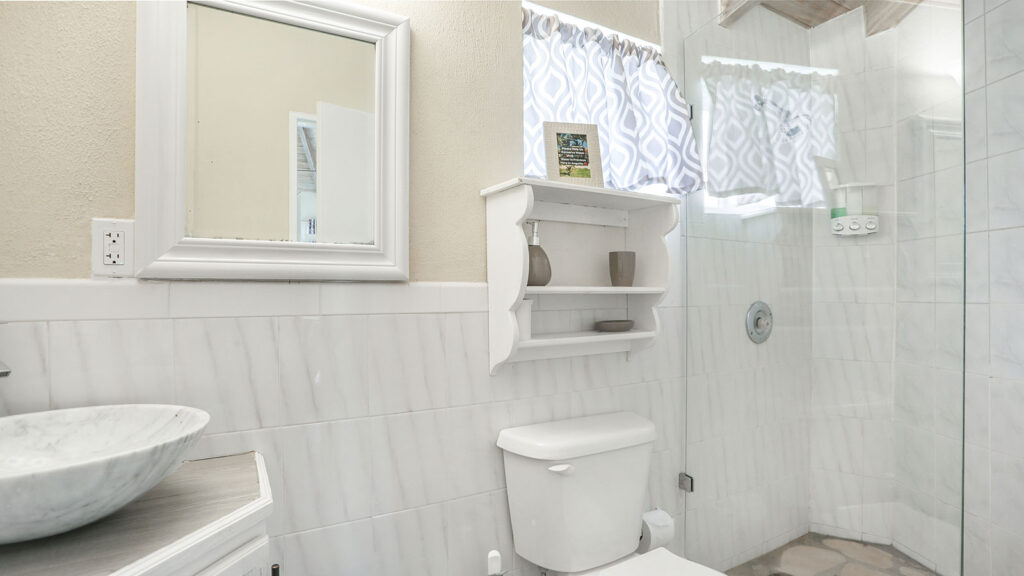 Arawak_suite-5-3_1600 Bathroom with glass shower, toilet, and vanity in the Sea Breeze Suite at Arawak Beach Club in Anguilla