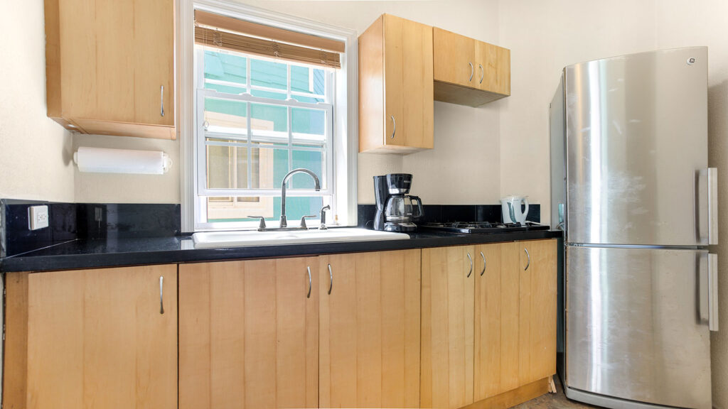 Arawak_suite-6-2_1600 Kitchen area with stove, coffee maker, and natural light in Ocean Bliss Suite at Arawak Beach Club in Anguilla
