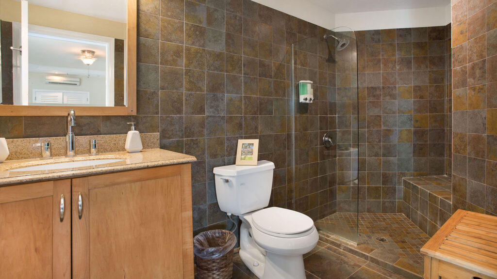 Arawak_suite-6-4_1600 Bathroom with dark tile, toilet, and vanity in Ocean Bliss Suite at Arawak Beach Club in Anguilla