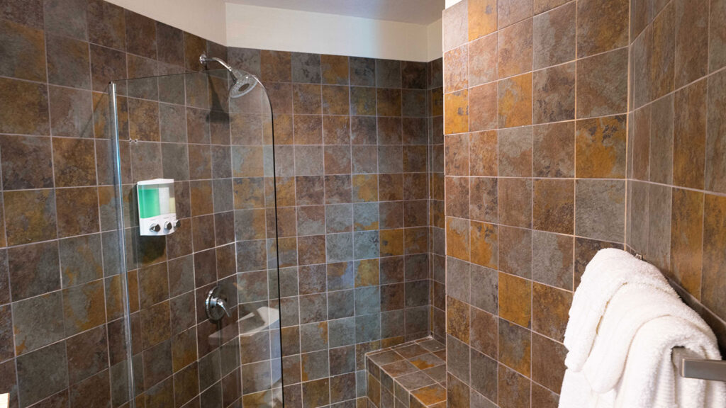 Arawak_suite-6-7_1600 Walk-in shower with dark tile in Ocean Bliss Suite at Arawak Beach Club in Anguilla