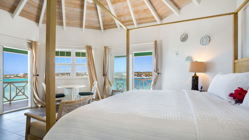 Arawak_suite-9-2_1600 King bed with tropical decor and vaulted ceiling in the Sea View Suite at Arawak Beach Club in Anguilla