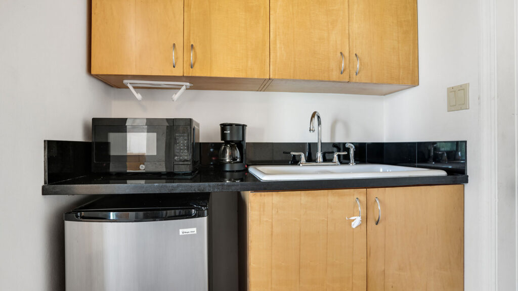 Arawak_suite-9-4_1600 Compact kitchenette with mini fridge, microwave, and sink in the Sea View Suite at Arawak Beach Club in Anguilla